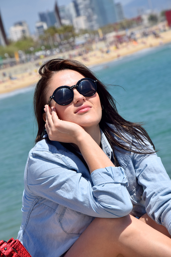 Best fashion blogger staying in the sun with sunglasses and denim shirt by Zara