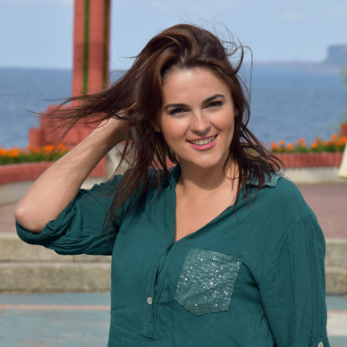 Andreea from Style Advisor wearing a green shirt.
